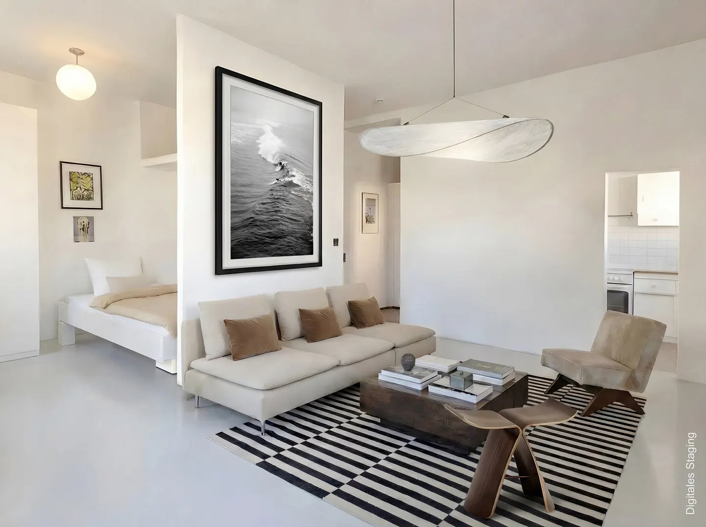 Bright, modern apartment with white walls, a beige sofa, and a black and white striped rug. A black-framed photo hangs above the sofa.