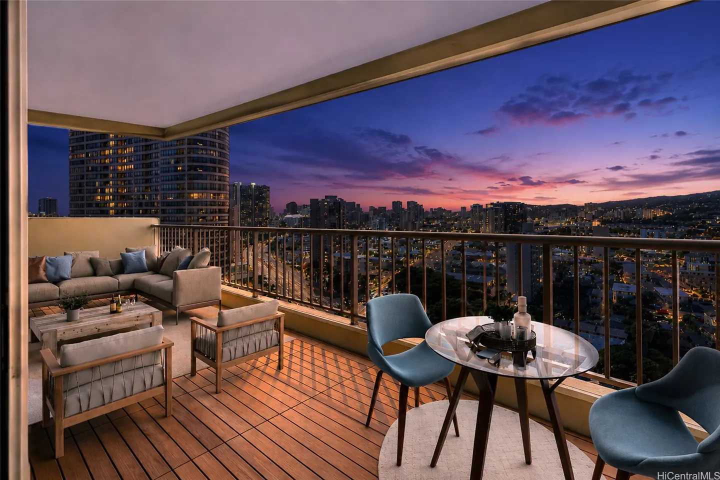 Modern balcony with outdoor seating, wooden floors, and a panoramic city view at sunset with a vibrant purple and orange sky.