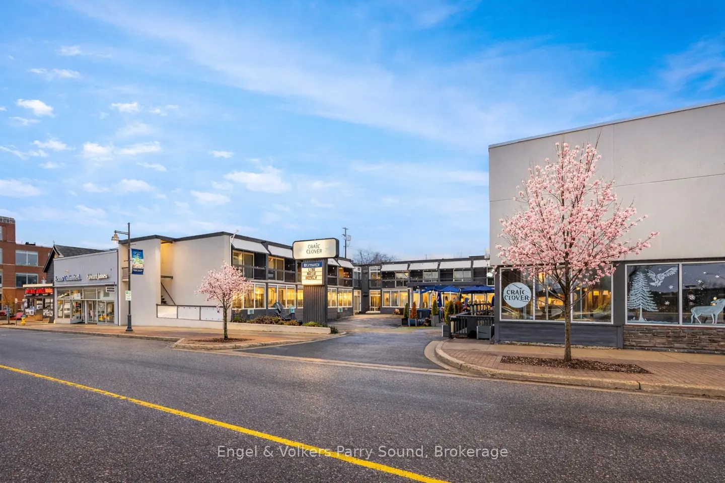 Street view of the Craic Clover restaurant with a pink flowering tree in front of the building.