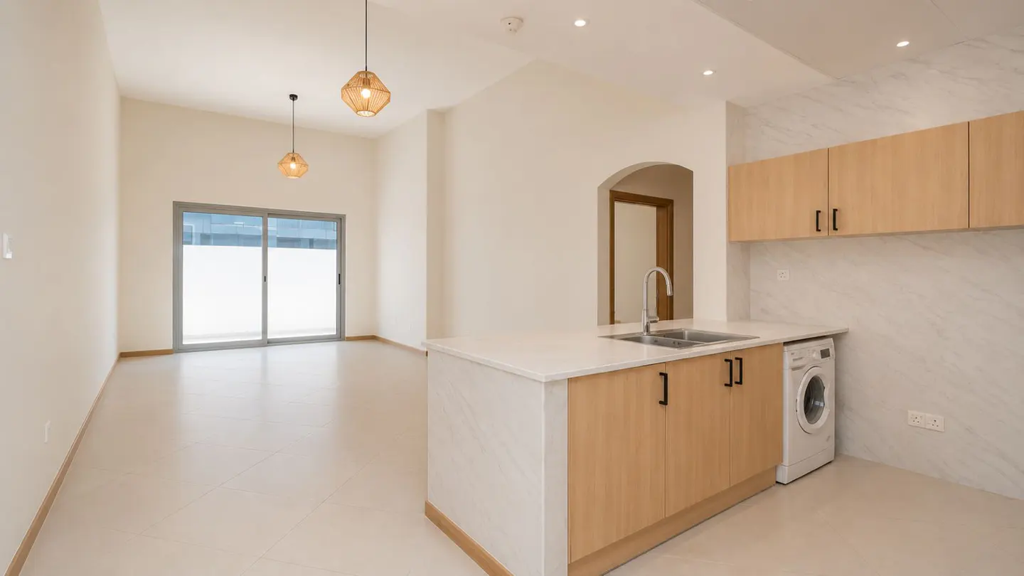 Bright, modern kitchen with light wood cabinets, white countertops, and a washing machine. A sliding glass door leads to a balcony.
