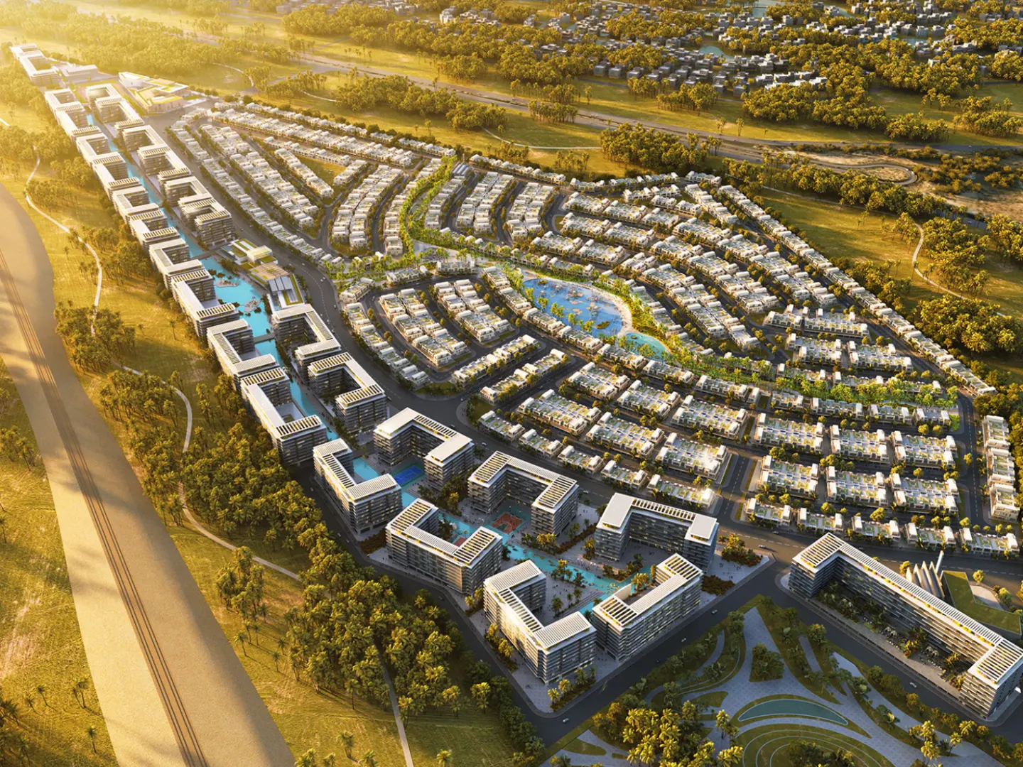 Aerial view of a modern residential complex with white buildings, green spaces, and blue water features.