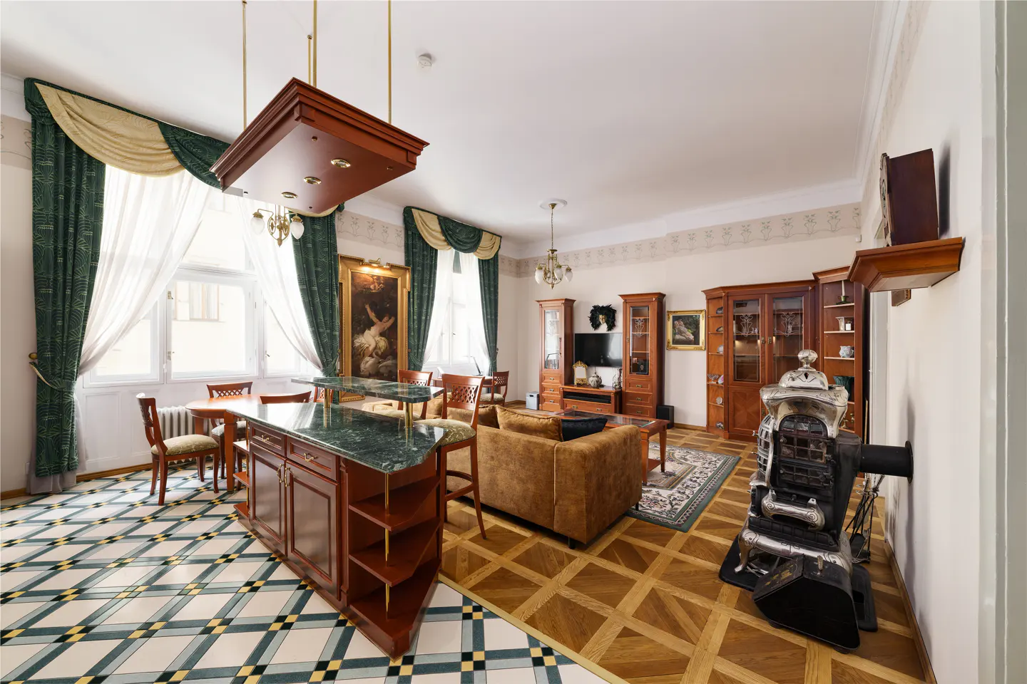 A wide shot of a living room with wood floors, a brown couch, and green curtains.