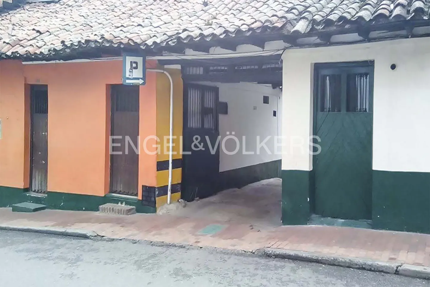 Exterior view of two buildings with a parking area in between, Engel & Völkers logo visible.