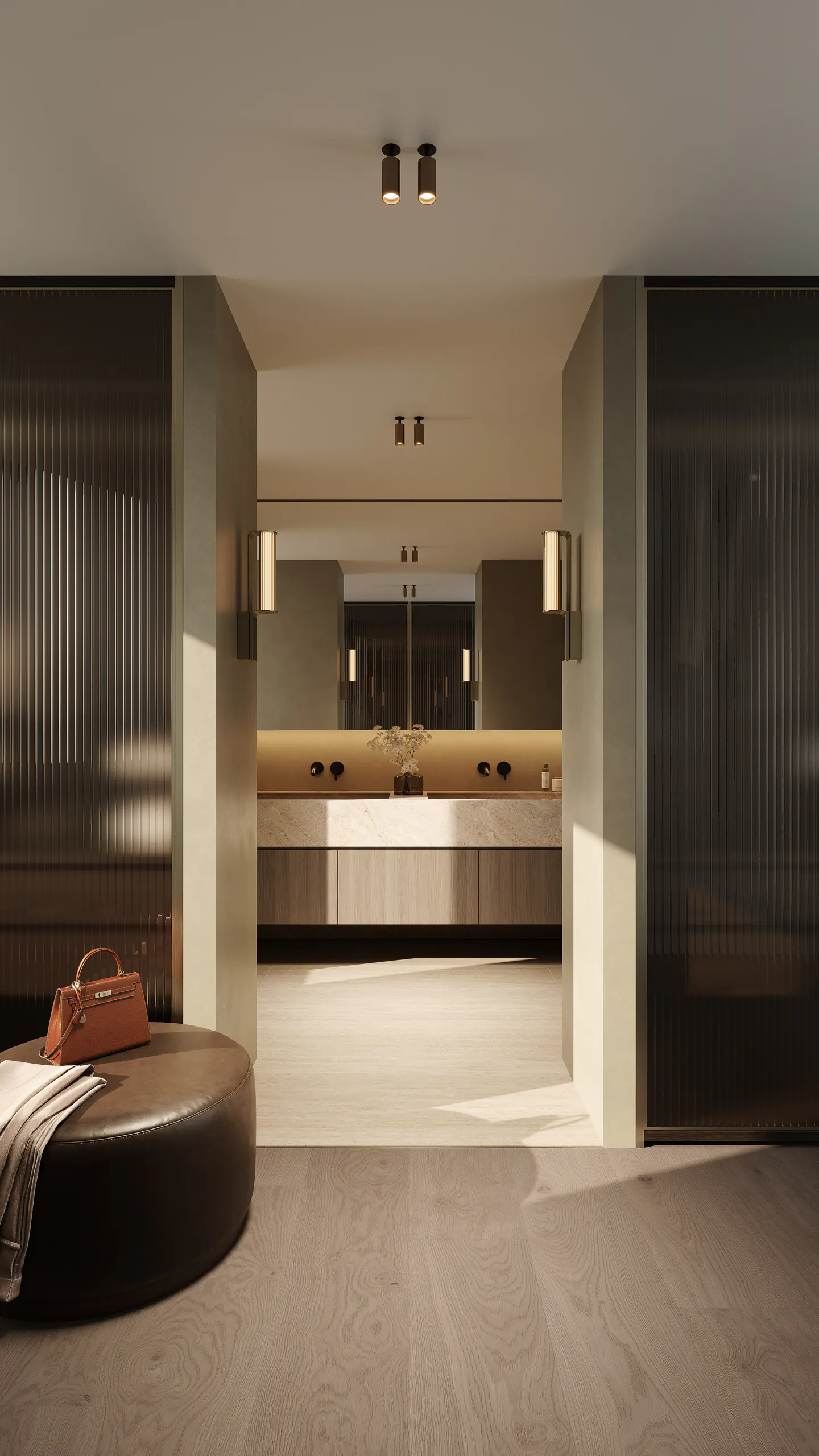 Bathroom entrance with a brown leather ottoman, a tan purse, and a gray blanket. The bathroom has a double sink and a mirror.