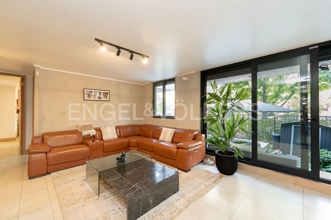 Living room with brown leather sectional sofa, marble coffee table, and sliding glass doors to a patio.