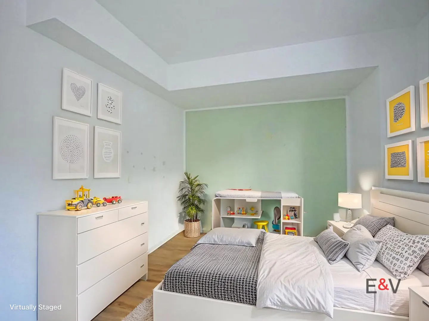 A child's bedroom with a white bed, dresser with toy cars, and a changing table with toys. The walls are light blue and green.