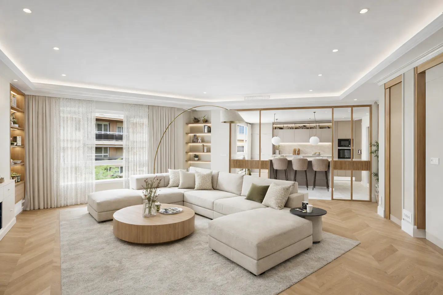 Bright living room with a large white sectional sofa, round wood coffee table, and herringbone wood floors. Kitchen visible in the background.