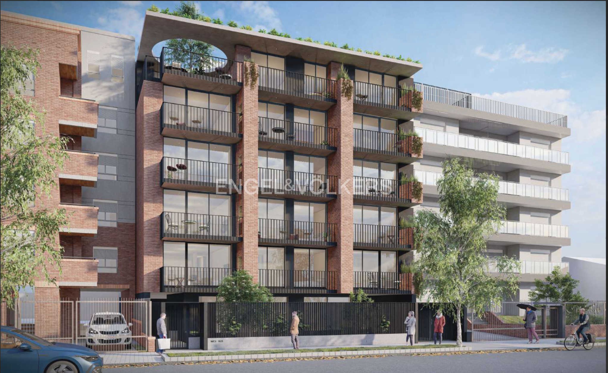 Modern apartment building with brick accents and black balconies. People walk on the sidewalk in front. Cars are parked nearby.