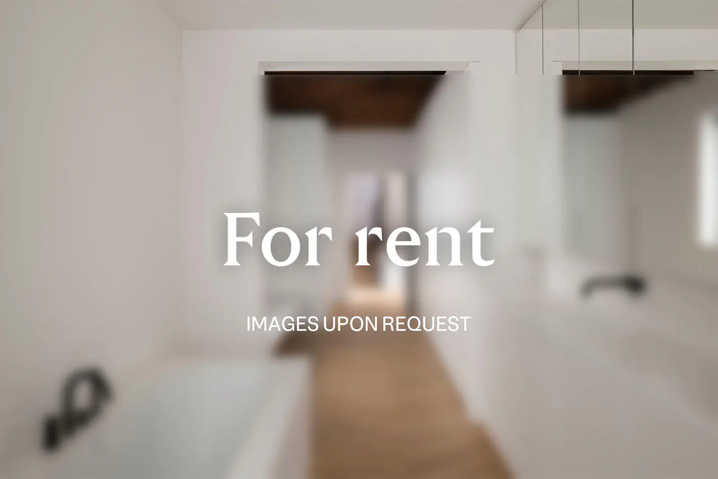 Blurred view of a white bathroom with a glimpse into a hallway. Text overlay reads "For rent, images upon request."