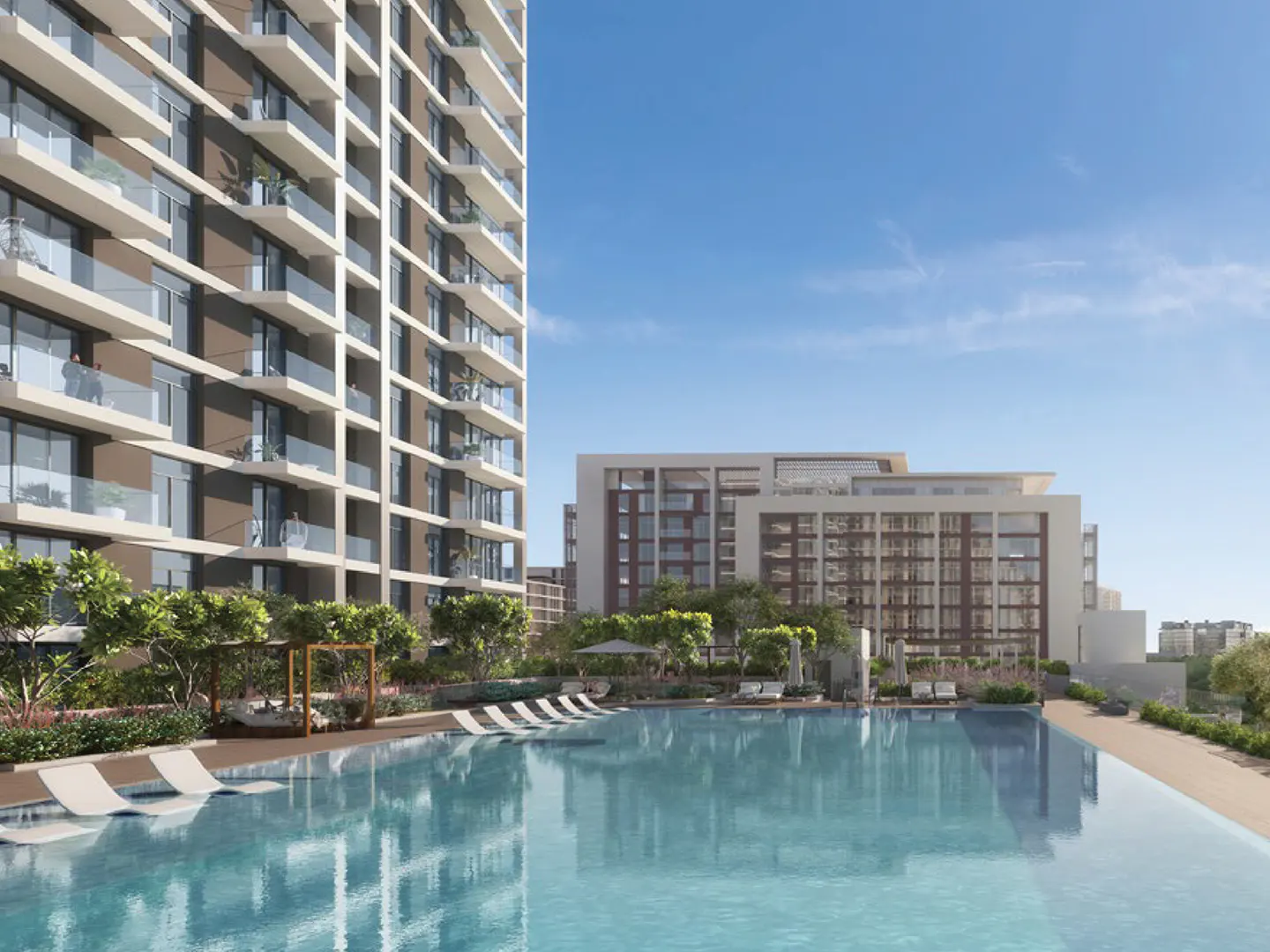 Exterior view of a modern apartment complex with a large swimming pool, lounge chairs, and balconies under a blue sky.