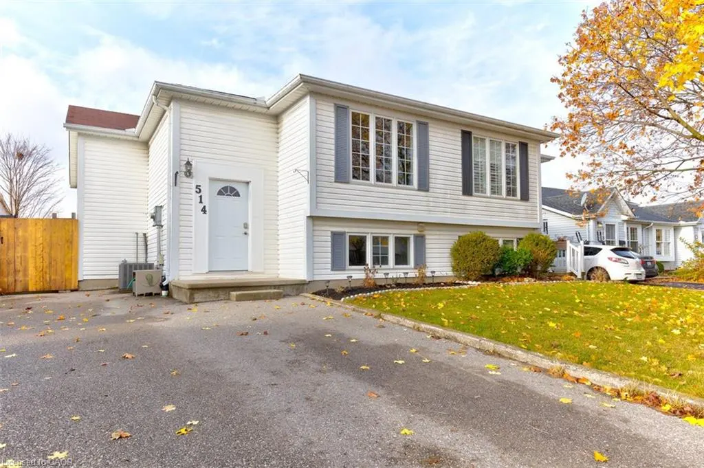 Two-story white house with gray shutters and a white front door at 514. A tree with yellow leaves is on the right.