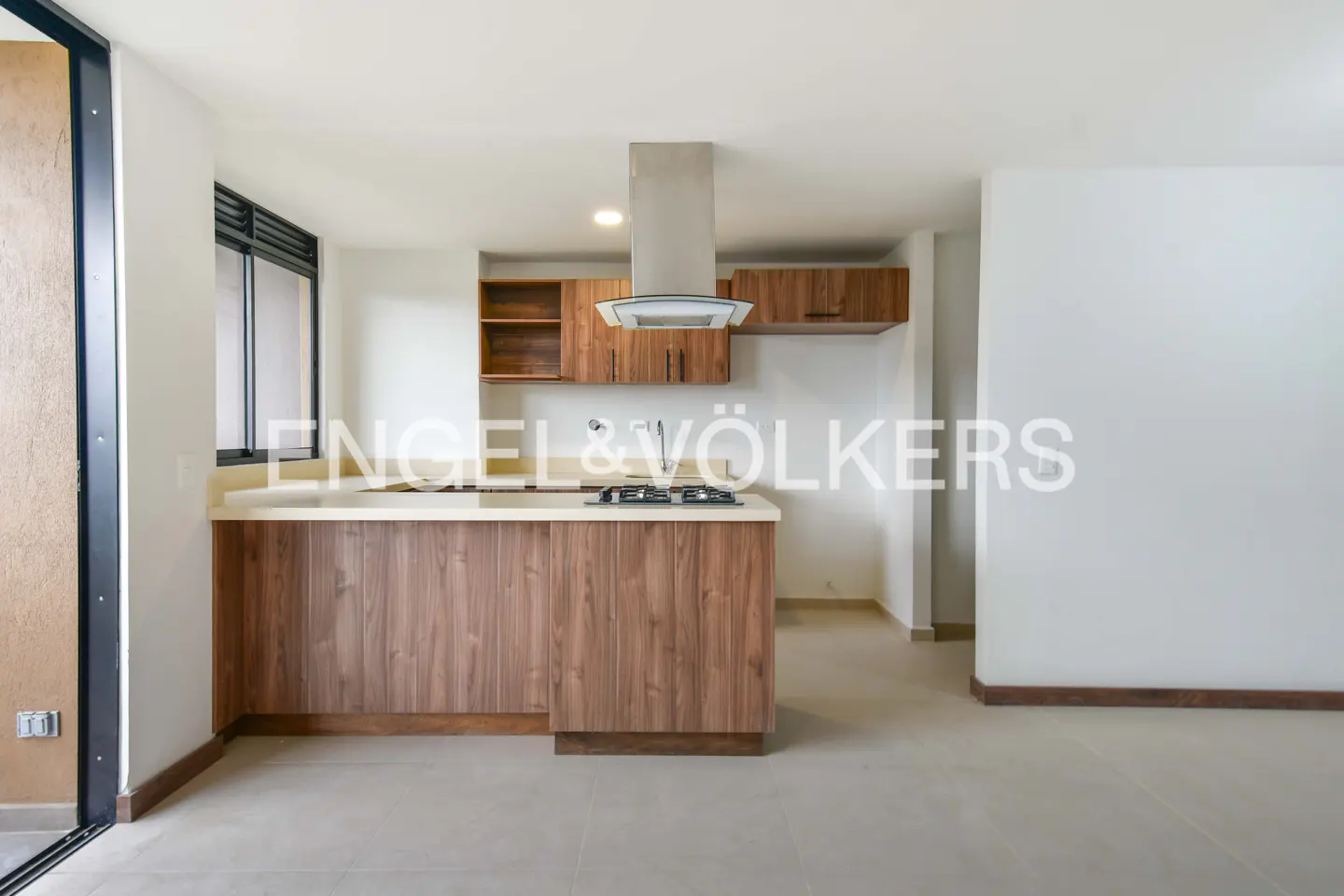 Modern kitchen with wood cabinets, white countertops, a stainless steel range hood, and a gas cooktop in an open floor plan.