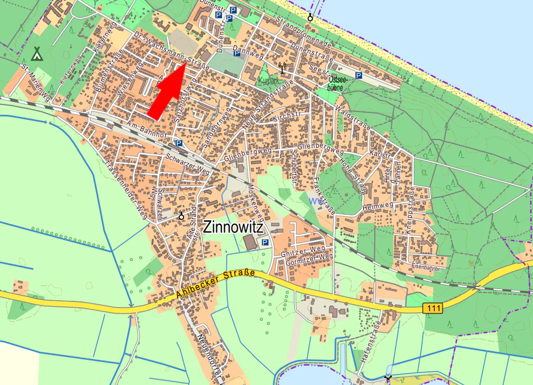 Map of Zinnowitz, Germany, with streets and landmarks. A red arrow points to Dr. Wachsmann-Straße. The Baltic Sea is visible in the background.
