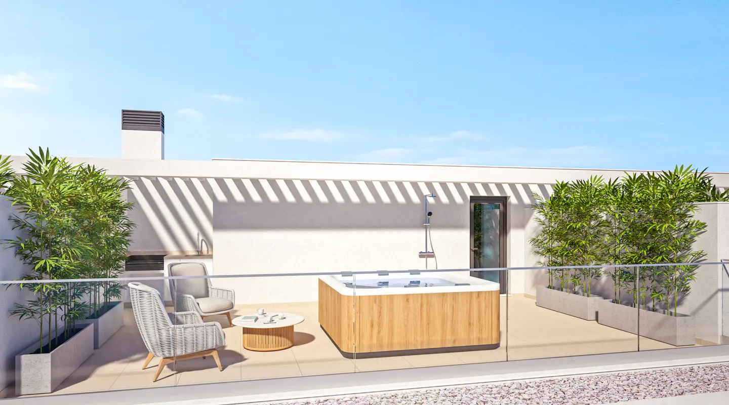 Rooftop patio with a wooden hot tub, two chairs, and a small table. Green plants line the edges, with a shower and door in the background.