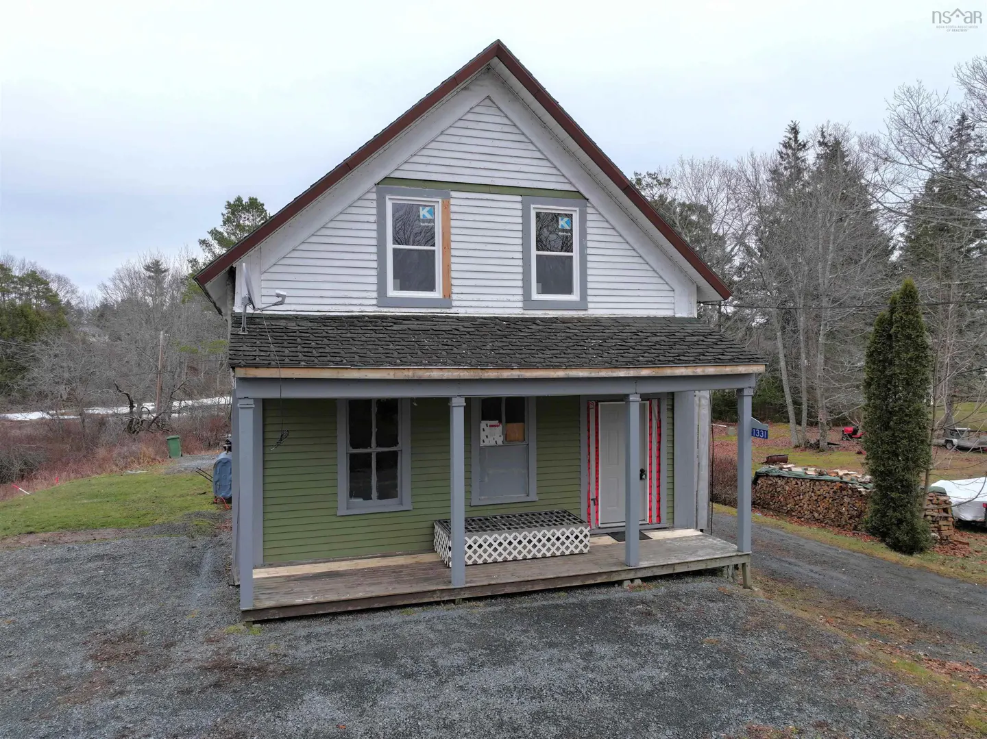 Two-story house with green siding and a gray porch. The roof is dark gray and the trim is white. Two new windows are on the second floor.