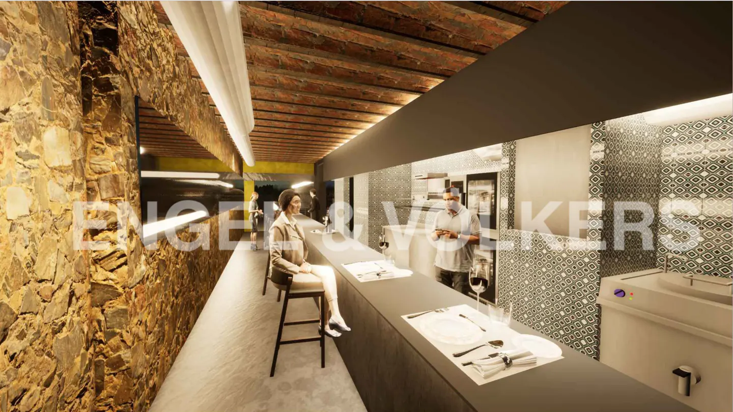 Interior view of a restaurant with a stone wall, brick ceiling, and a long bar with patrons and staff.