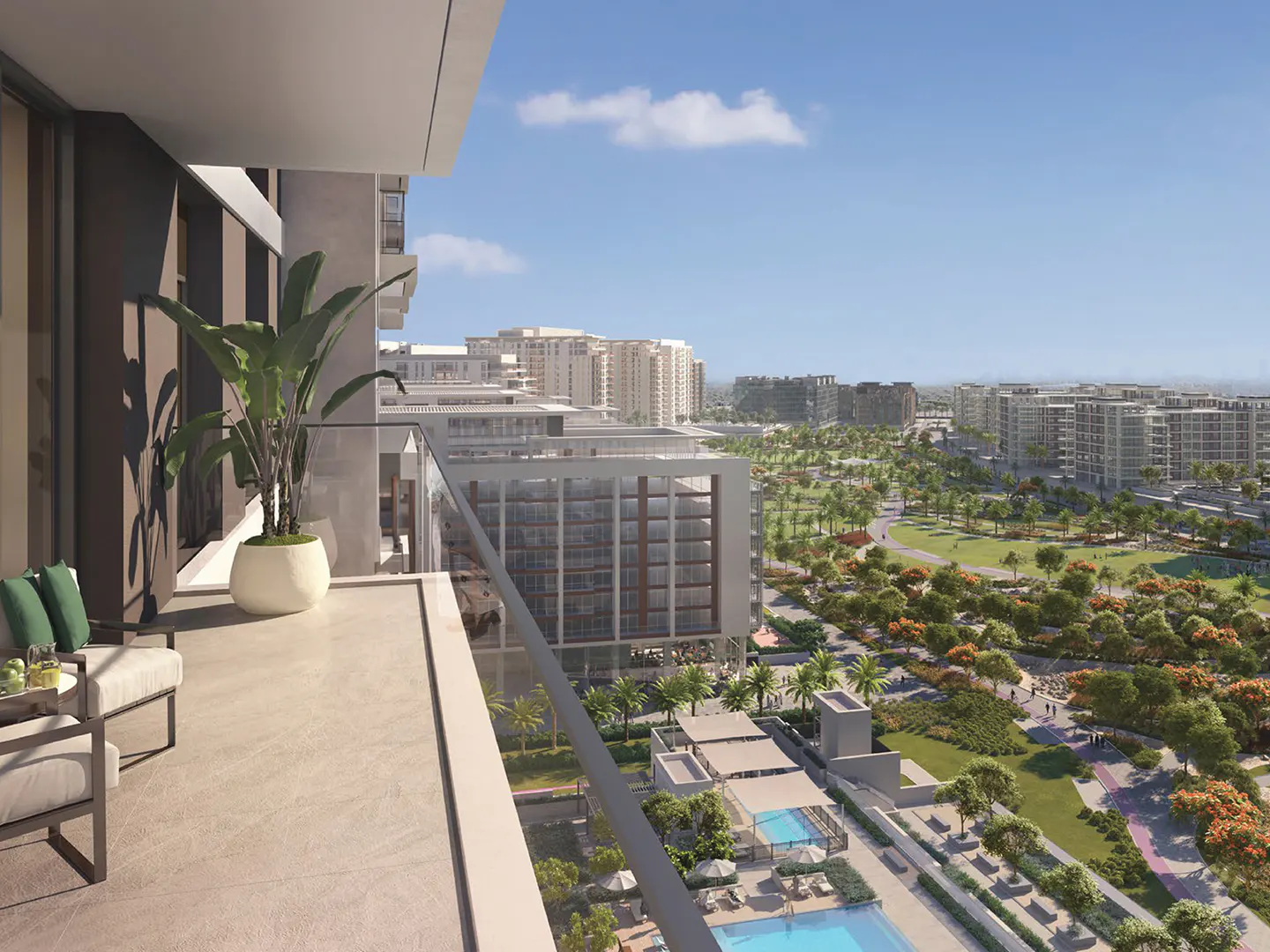 Balcony view with seating, plant, and city skyline. Glass railing overlooks pools, park, and buildings under a blue sky.