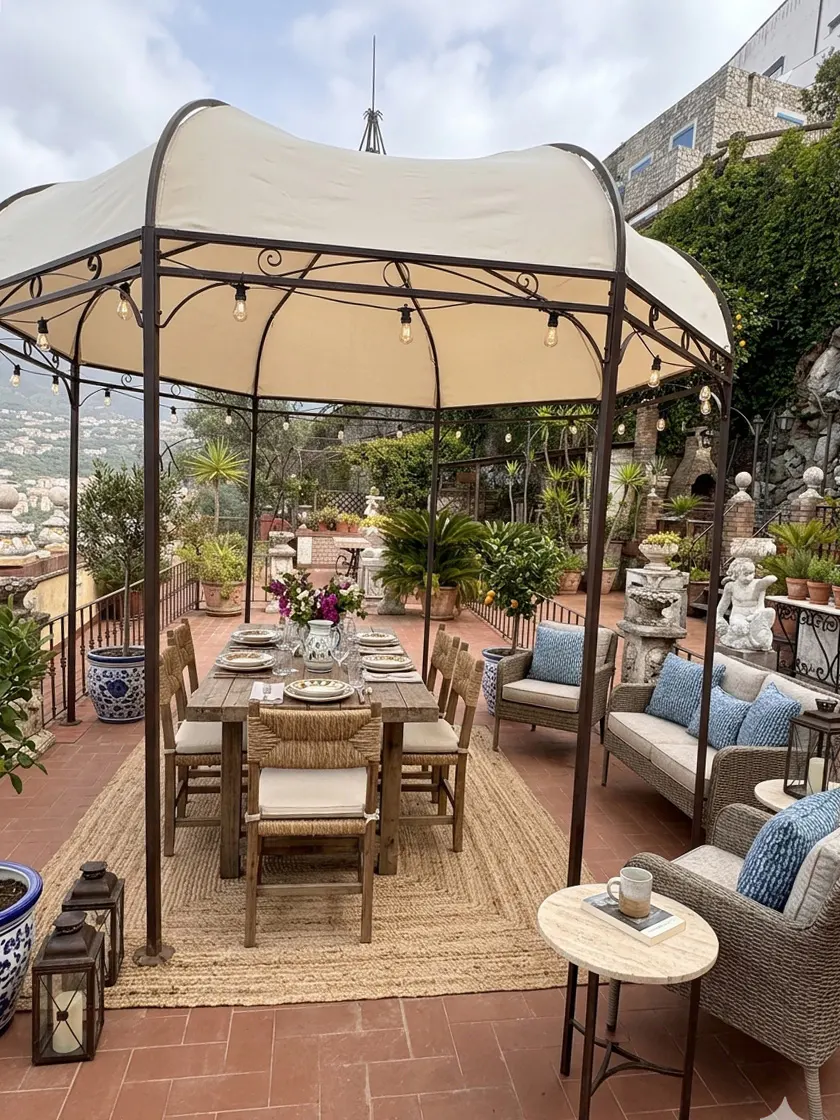 Outdoor patio with a dining table under a canopy, surrounded by plants and seating areas. The table is set for a meal.