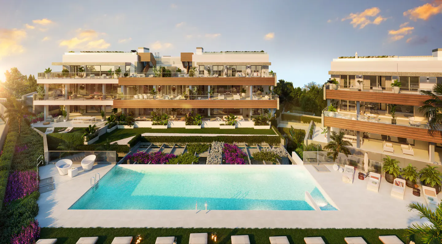 Aerial view of a modern, multi-story apartment complex with a large, rectangular pool, lounge chairs, and lush landscaping.