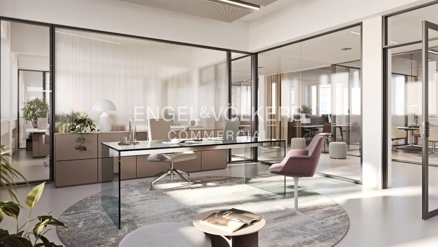 Modern office space with glass walls, a glass desk, and a round rug. Engel & Volkers logo is visible on the glass wall.
