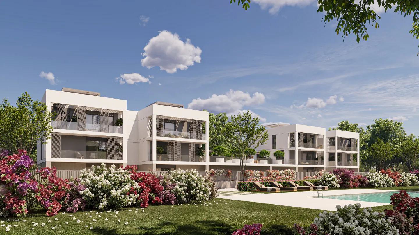 Modern white apartments with balconies overlook a pool and lawn with colorful flowers under a blue sky.