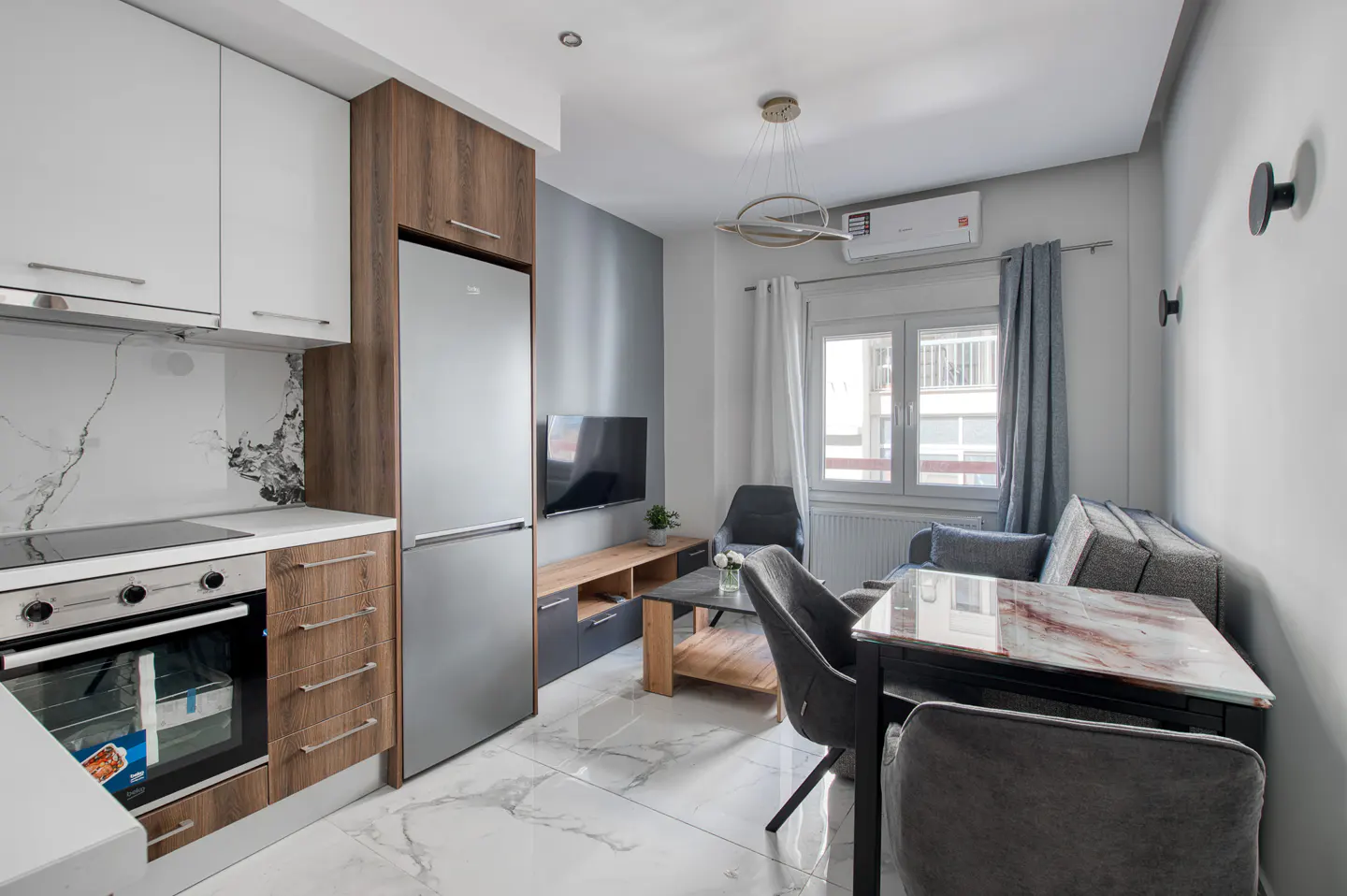 A modern apartment interior with a kitchen, dining area, and living room. White marble floors and gray walls create a sleek look.