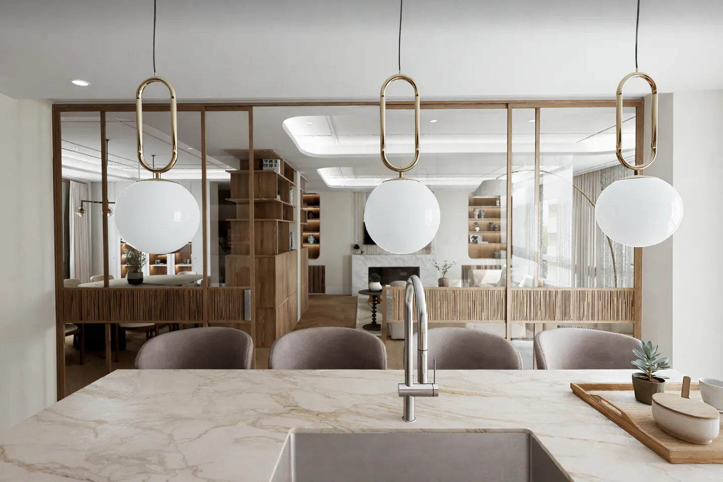 A modern kitchen with marble countertops, a sink, and three white globe pendant lights with gold accents. The background shows a living area with wooden shelves.