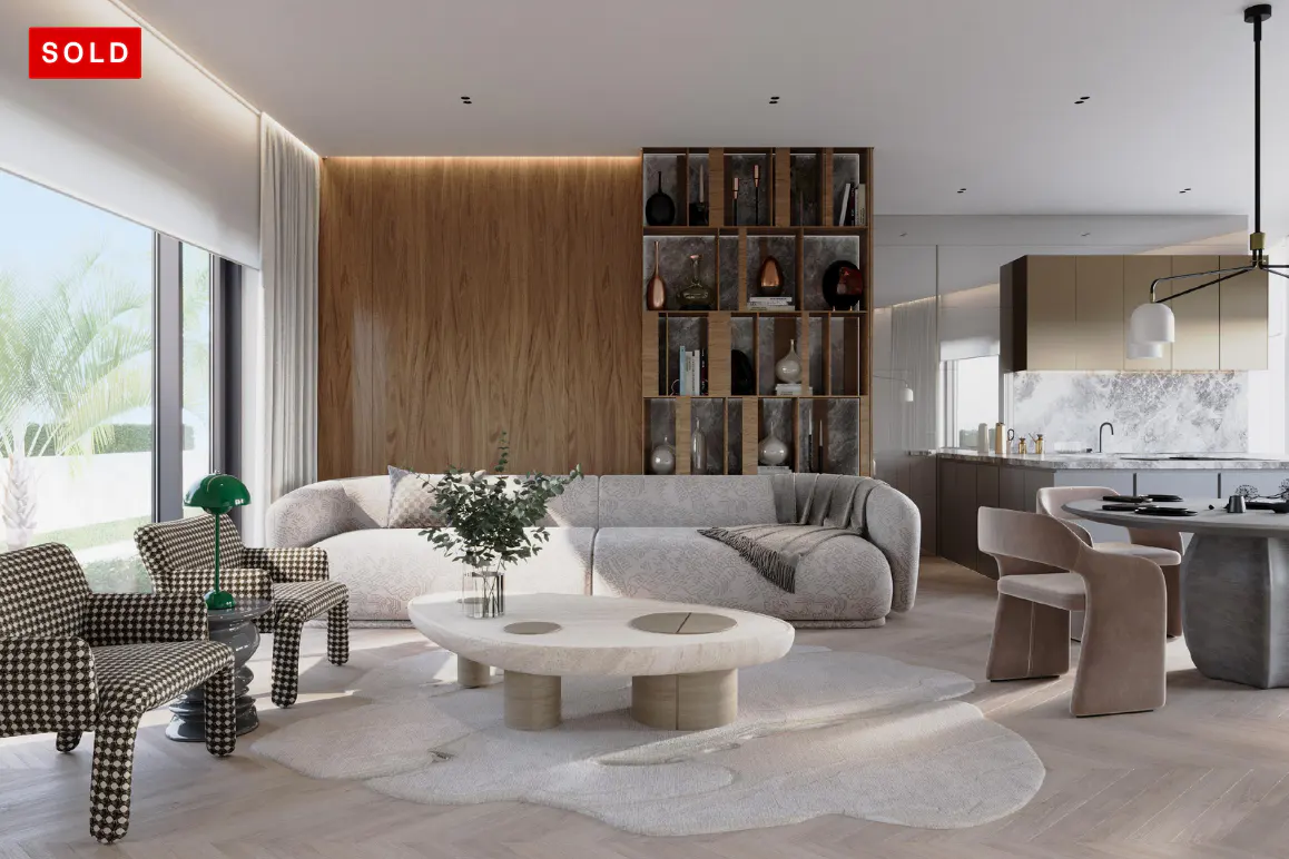 A modern living room with a gray sofa, stone coffee table, and houndstooth chairs. A kitchen is visible in the background. "SOLD" in red is in the upper left.