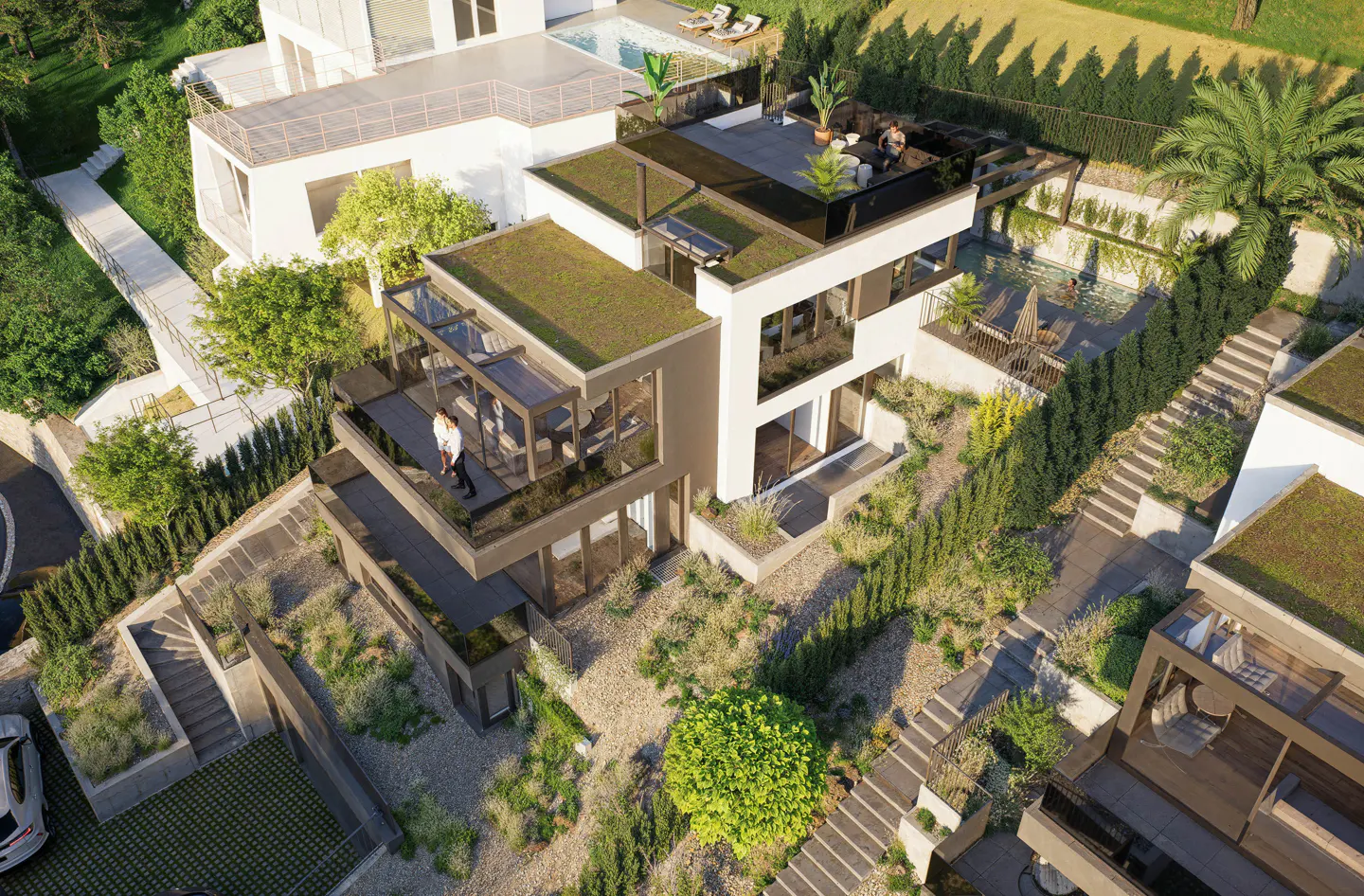 Aerial view of a modern white house with green roof, balconies, pool, and lush landscaping on a hillside.