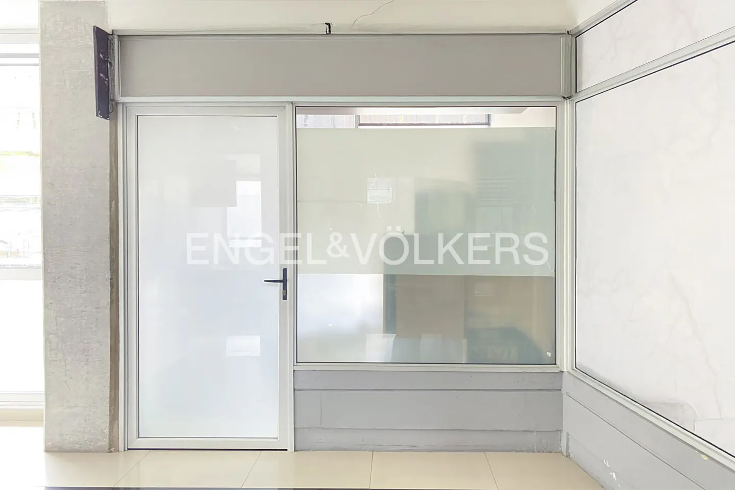 Engel & Völkers office entrance with a white door and frosted glass window displaying the company logo.
