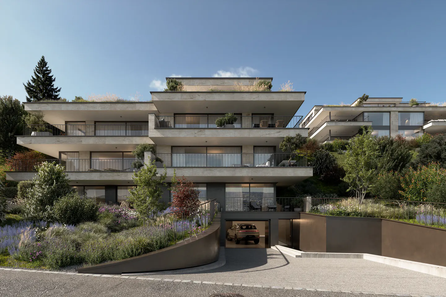 Modern apartment building with balconies and a car parked in the garage. The building is surrounded by greenery and flowers.