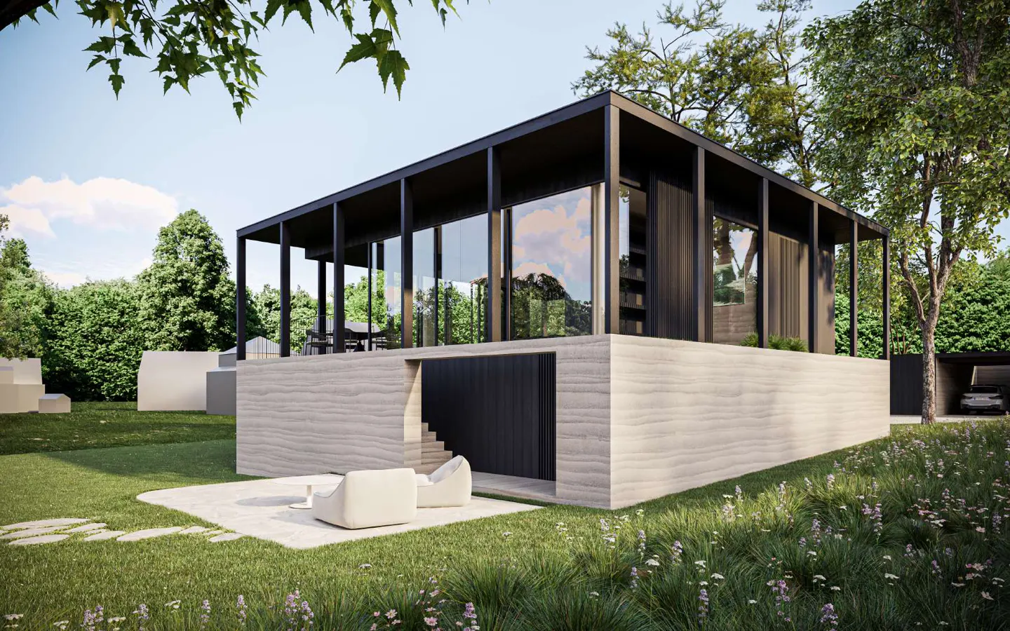 Modern house with black frame, glass walls, and concrete base. Lawn, trees, and white chairs in the foreground.