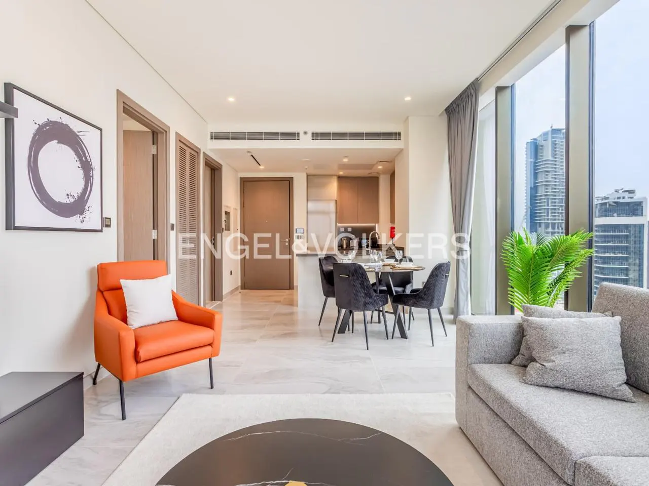 Bright, modern apartment interior with orange chair, gray sofa, dining table, and city view through large windows.