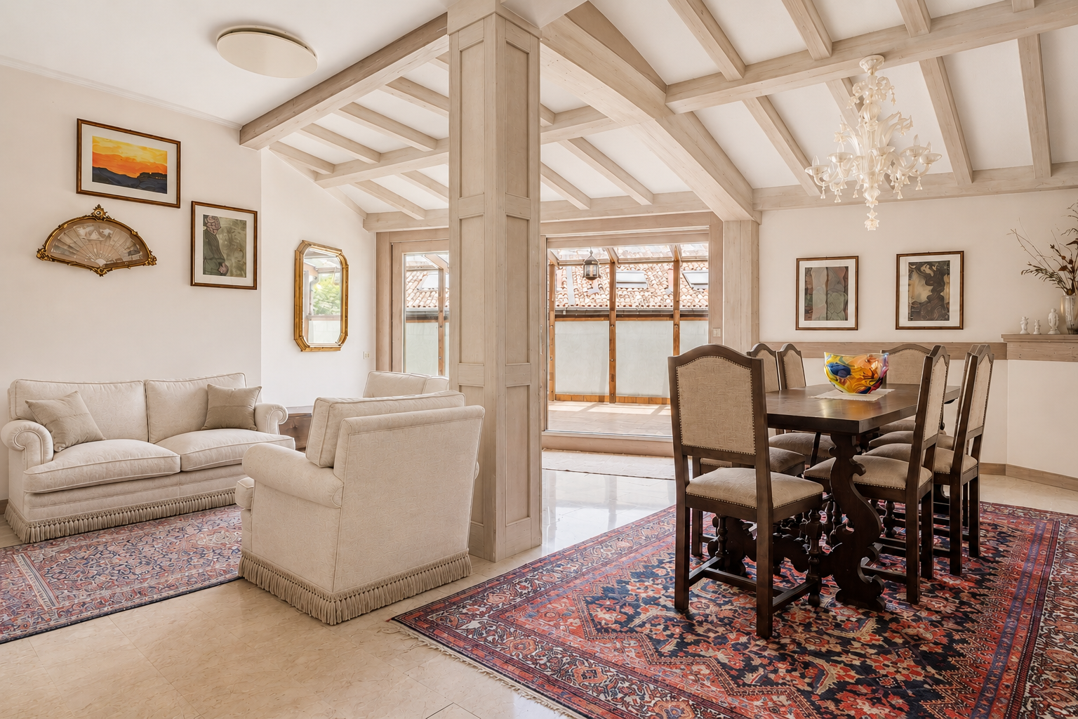 Open-plan living and dining area with cream sofas, a wooden dining set, ornate rugs, and exposed ceiling beams. [AI-generated text] [AI-modified]