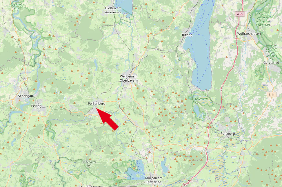 Map of Peißenberg, Germany, with a red arrow pointing to the town. Lakes and forests surround the area.