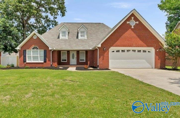 Single-story red brick house with a white garage, dormer windows, and a green lawn under a clear blue sky.
