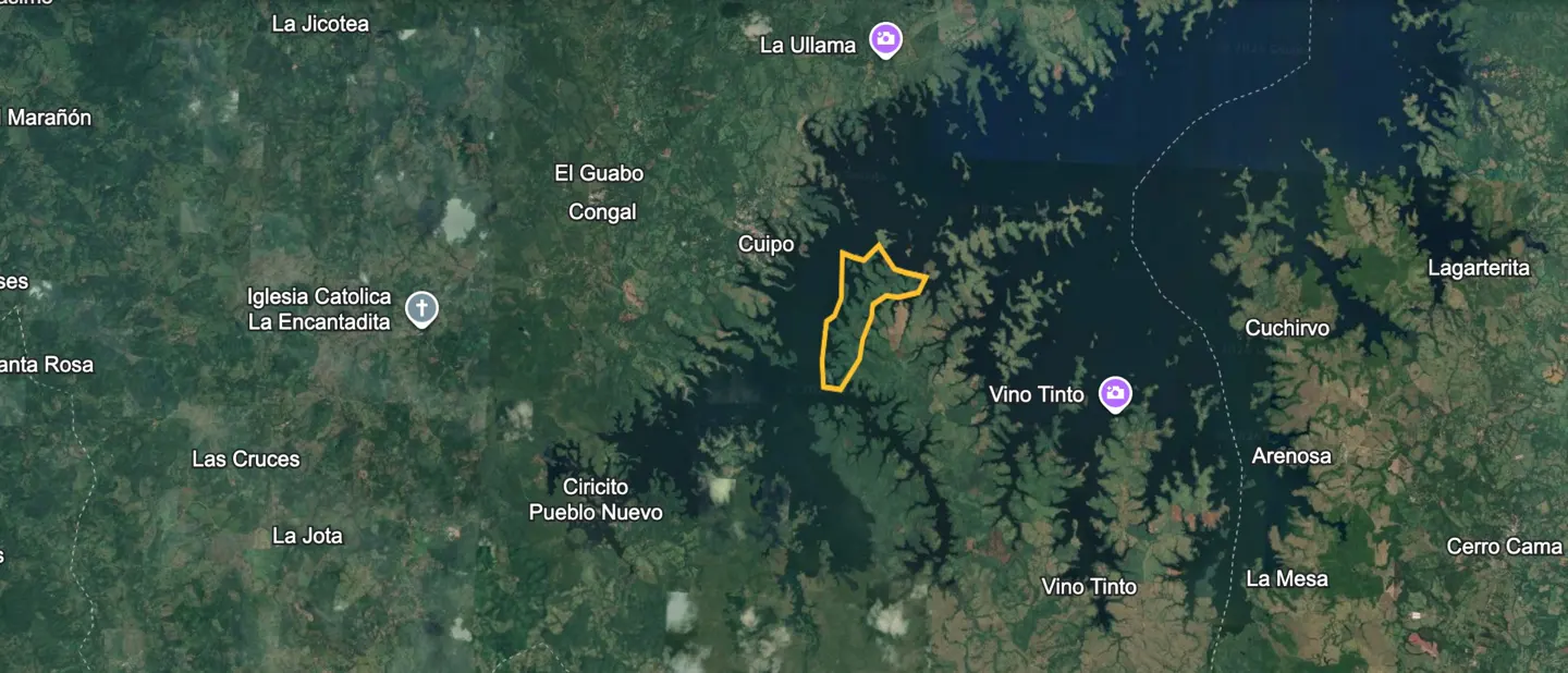 Aerial view of a green, hilly landscape with a lake, outlined in yellow.