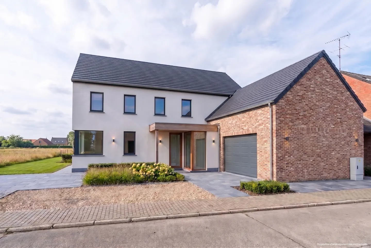 Two-story house with a gray roof, white stucco, and brick garage. A paved driveway leads to the gray garage door.