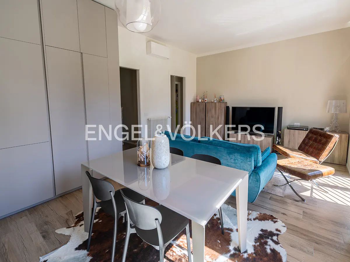 Living room with a white table, gray chairs, a blue sofa, and a brown leather chair on a cowhide rug.