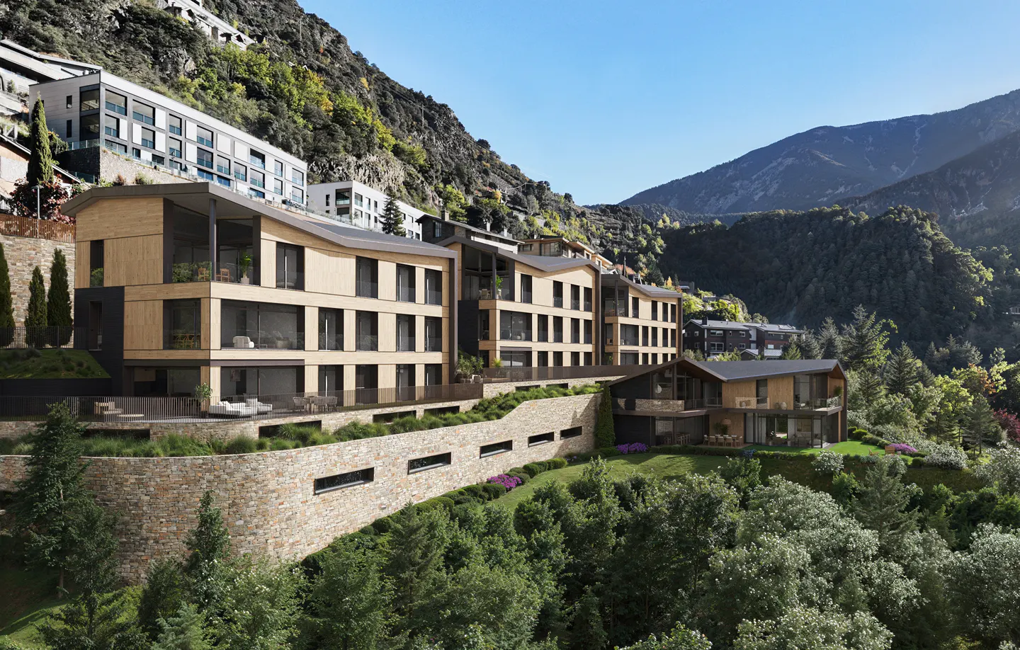 Modern wood-paneled condos nestled into a green hillside with mountains in the background under a clear blue sky.