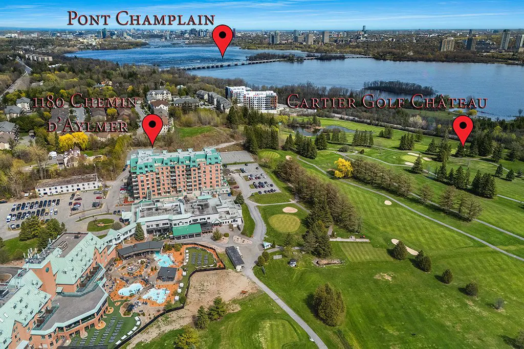 Aerial view of a resort with a golf course, pools, and a view of the Pont Champlain bridge and Ottawa skyline.