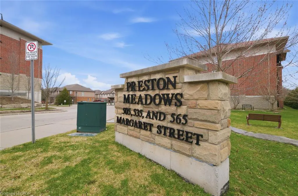 Stone sign reads "Preston Meadows, 505, 535, and 565 Margaret Street" on a grassy lawn with brick buildings in the background.
