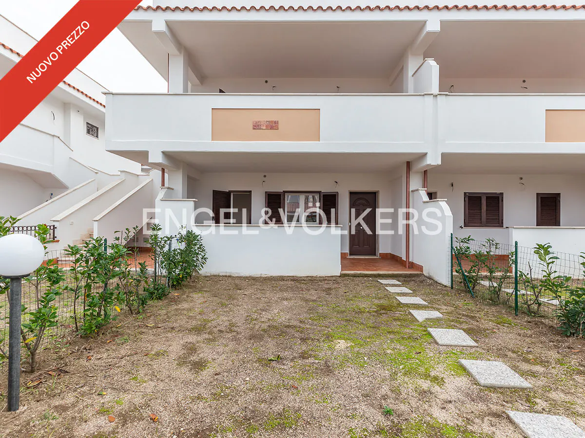 Two-story white townhouse with a small yard and stone path. Red banner in the corner says "Nuovo Prezzo".