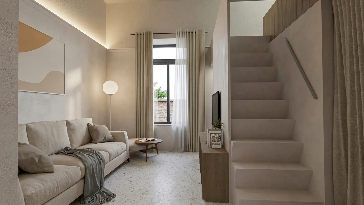Living room with beige sofa, round table, and stairs. A floor lamp stands near a window with curtains. A TV and cabinet are near the stairs.