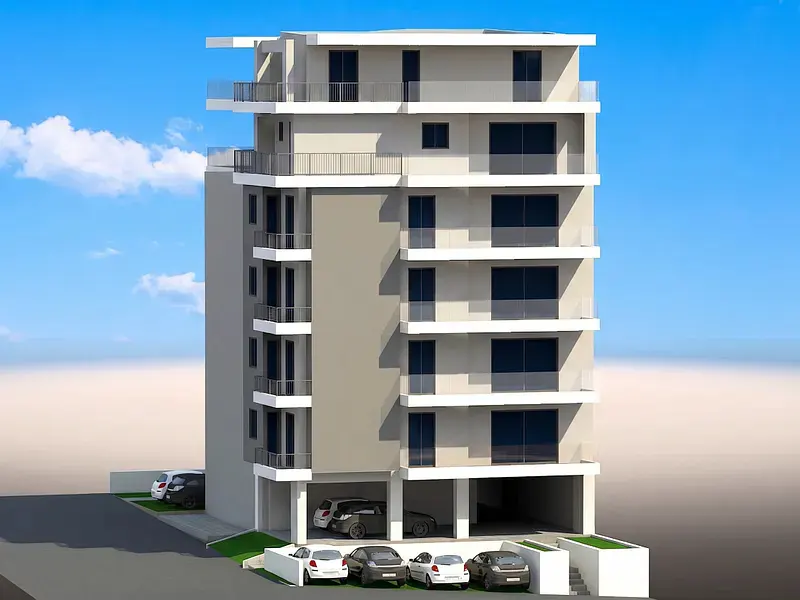 Modern multi-story apartment building with balconies, glass railings, and ground-level parking against a blue sky.