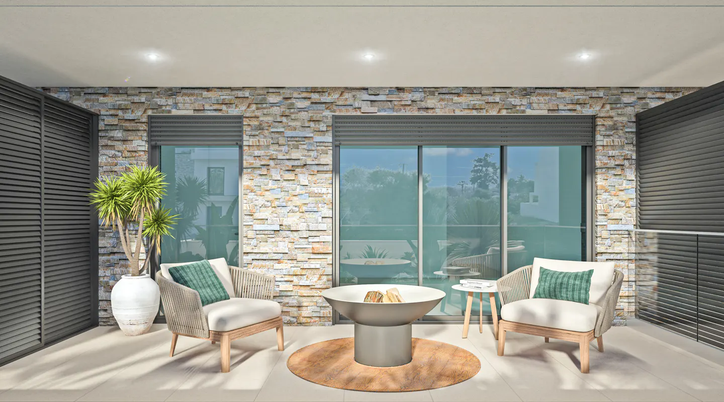 Outdoor patio with stone wall, gray shutters, and glass doors. Two chairs face a modern fire pit on a round rug. A potted plant sits to the left.