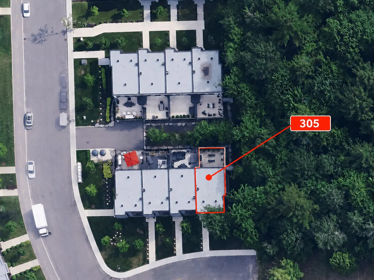 Aerial view of townhouses, with "305" pointing to one unit bordered in red, next to a green wooded area.