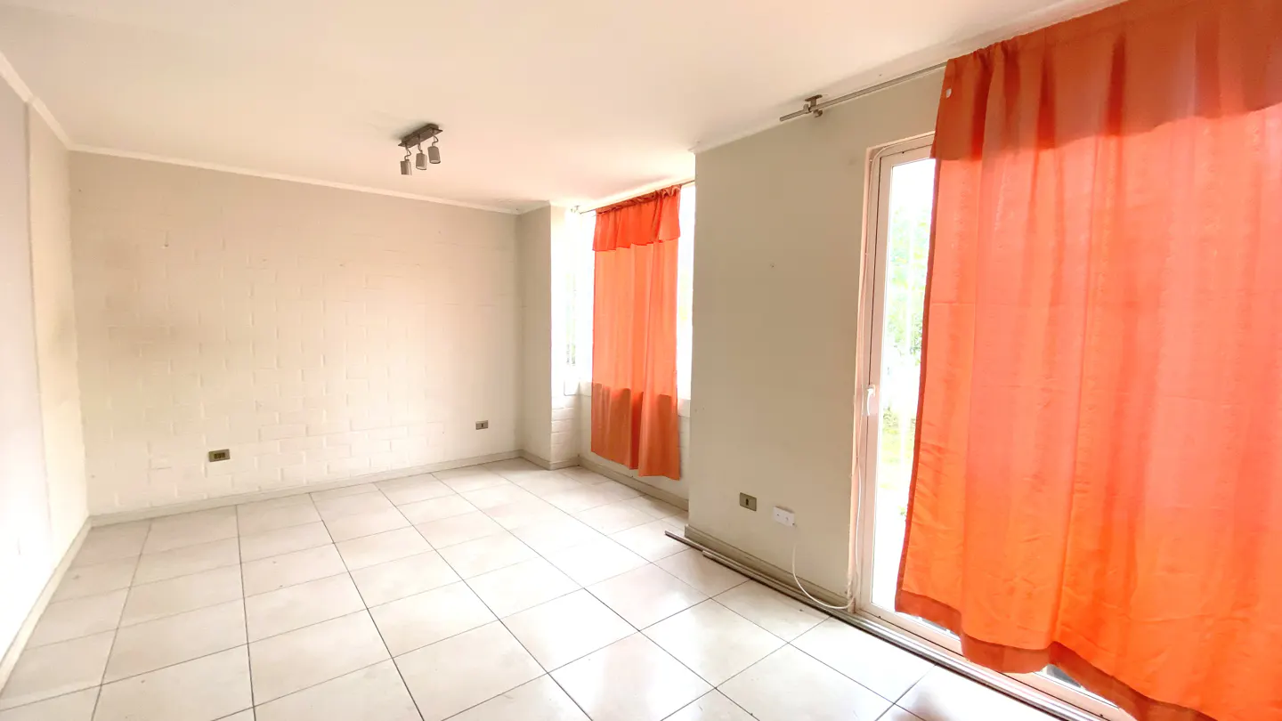 Empty room with white tile floor, light gray walls, and orange curtains covering windows and a sliding glass door.
