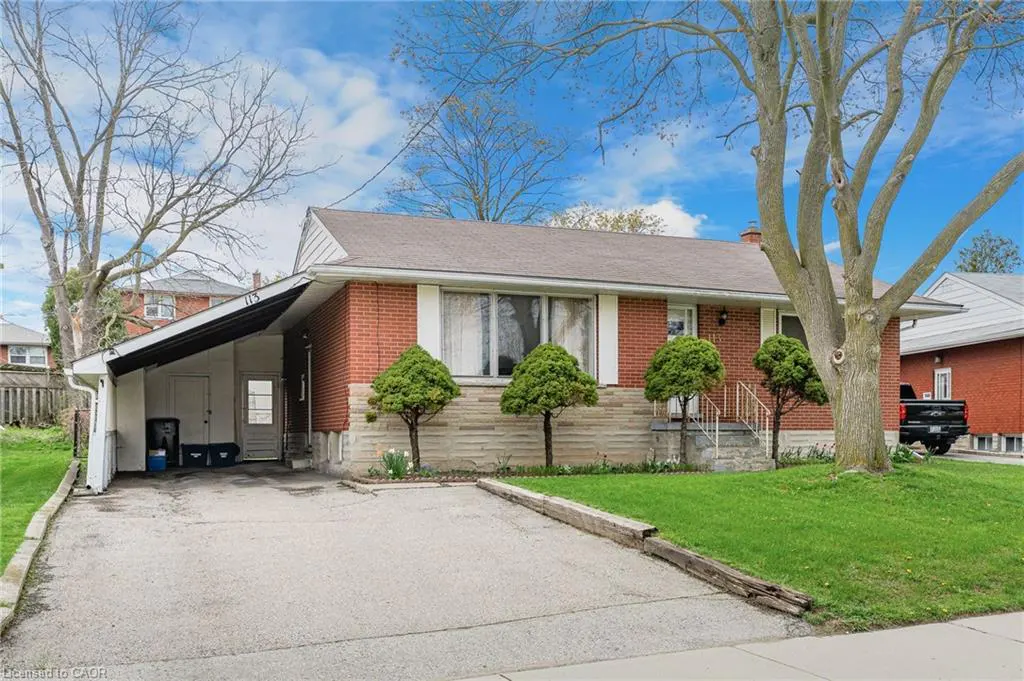 A red brick bungalow with a carport, a concrete driveway, and a green lawn.