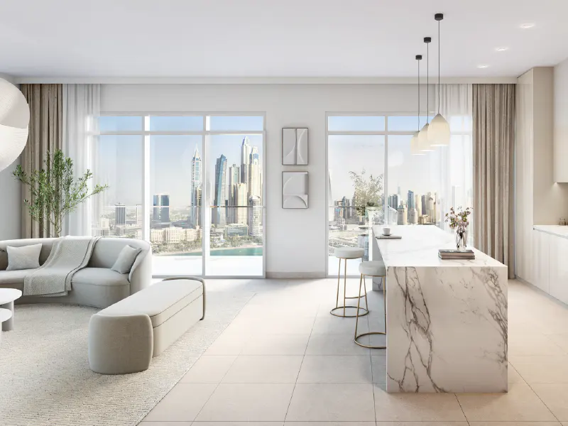 Bright, modern apartment interior with a curved gray sofa, marble island with stools, and a city view through large windows.